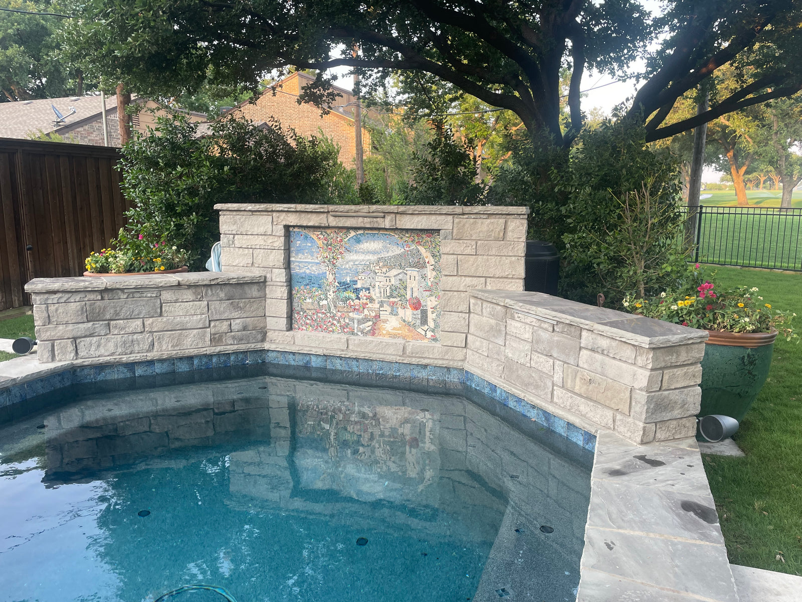 Mosaic mural above a garden fountain
