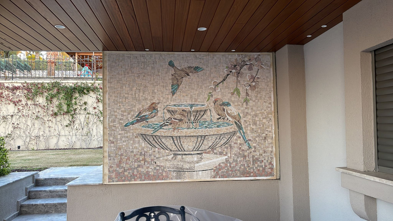 Birds and fountain marble mosaic on a patio