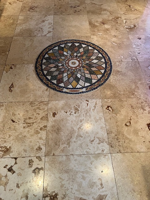 Geometric marble mosaic medallion in a stone floor